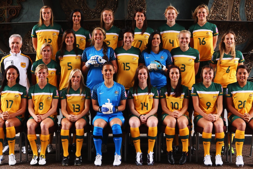 The Matildas pose for a World Cup team photo in their green and gold kit
