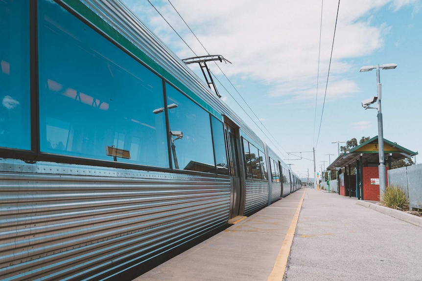 A train sits idle at Seaforth Station alongside an empty platform.