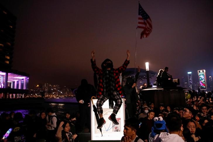 A protester sits above a sign during demonstrations on new years eve.