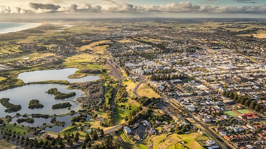 An aerial image of Warrnambool city with the coastline in the background.