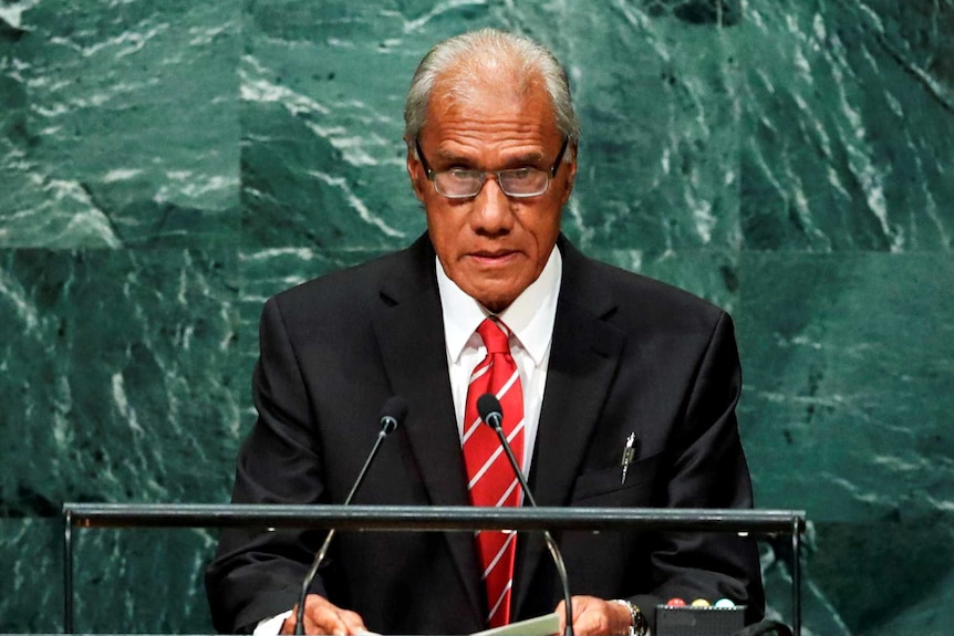 Akilisi Pohiva stands a lectern making an address at the United Nations.