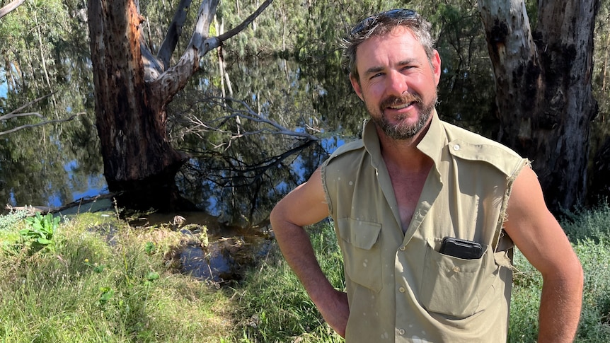 Ben Mansell stands on the edge of the swollen Murray River