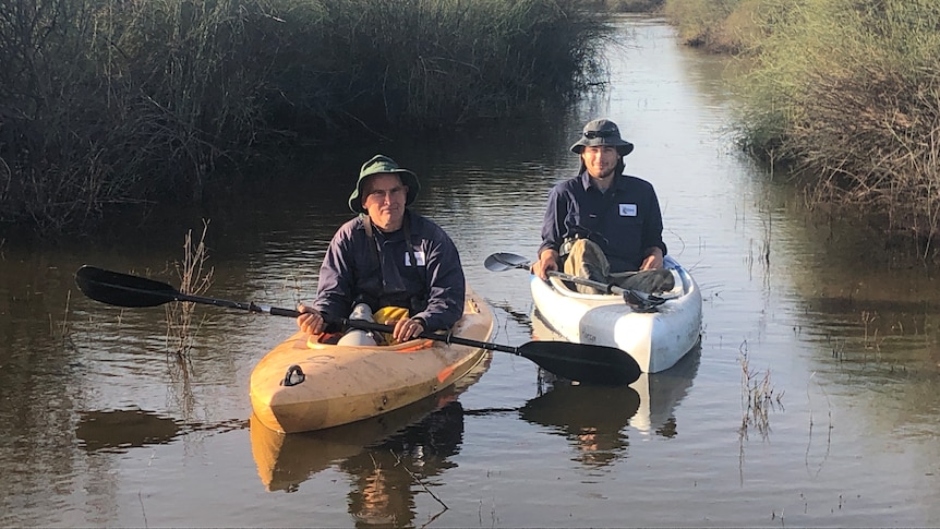 Photo of two men on kayaks.