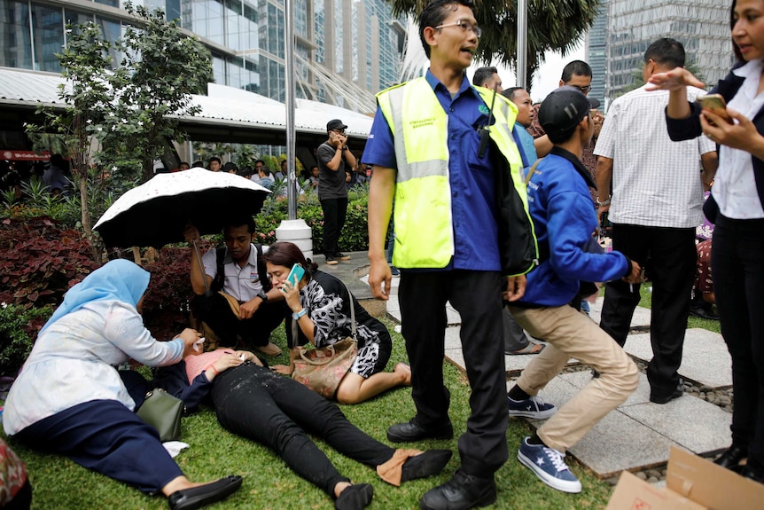 Injured people are treated outside the Indonesian Stock Exchange building.
