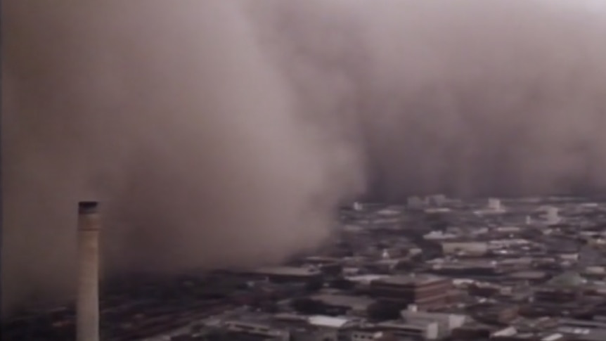 An aerial shot of the city shows a huge cloud of dust descending on the city 