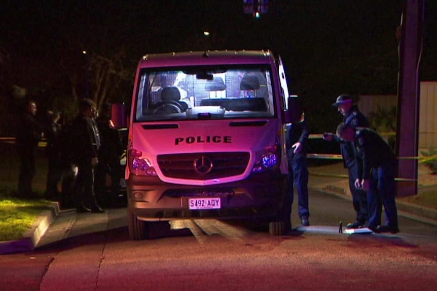 Police gather around the CIB van near the crime scene