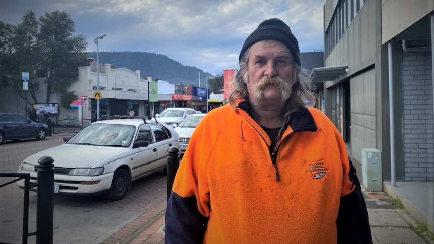 Ray Green wears a high-visibility jacket and stands in a street.