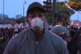 A black TV reporter is handcuffed by armoured police on a street in Minneapolis