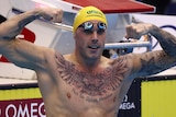 Kyle Chalmers flexes his biceps in the pool after winning a race