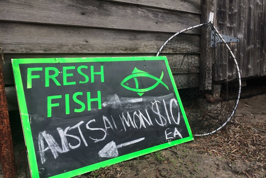 A green and black sign that read "Fresh Fish, Australian Salmon $10" sits in front of one of the old Parry's fishing shacks.
