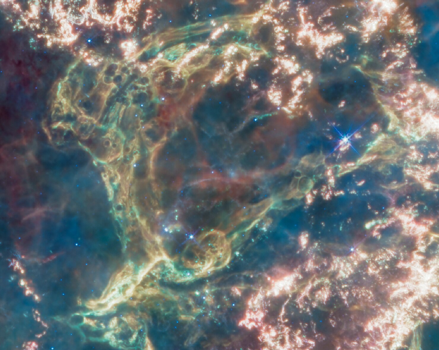 A section of Cassiopeia A with green wisps of cosmic gas and bubbles