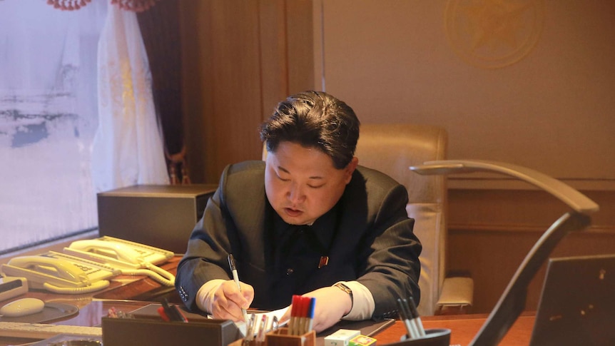 Kim Jong-Un signing a document.