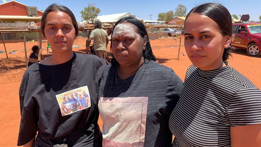 Samara Fernandez Brown, Natasha Fernandez Brown and Joyce Brown look at the camera in the streets of the Yuendumu community.