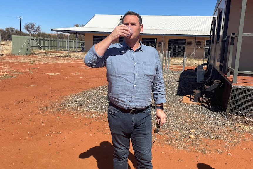 A man drinks water in a remote Indigenous community.