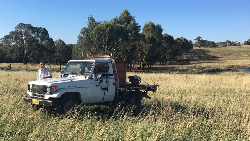 Farmer David Marsh standing next to his ute on his property at Boorowa with lush grass in the foreground.