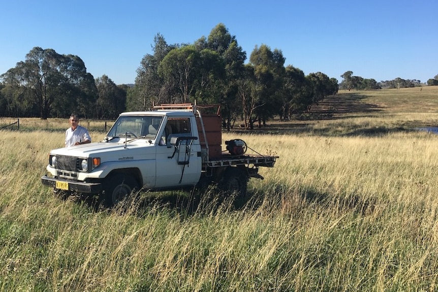 Farmer David Marsh standing next to his ute on his property at Boorowa with lush grass in the foreground.