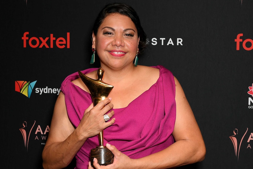 Deborah Mailman holds an award on the red carpet