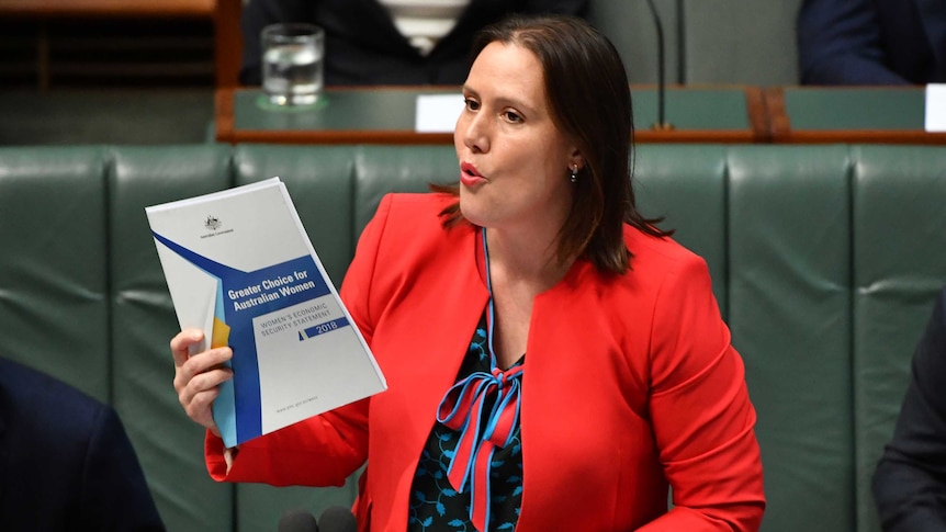 Kelly O'Dwyer holds up a document titled "greater choices for Australian women" while speaking into a microphone in Parliament