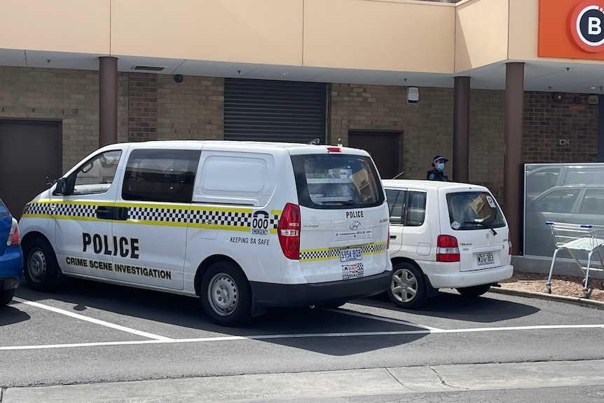 Een politie-onderzoeksbusje geparkeerd op de parkeerplaats van een winkelcentrum