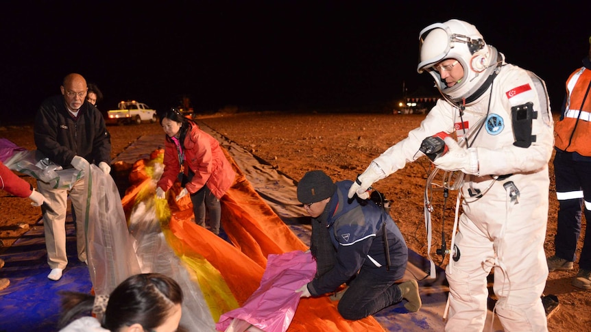 Mr Lim Seng in an astronaut suit overseas the last minute preparations of balloon.