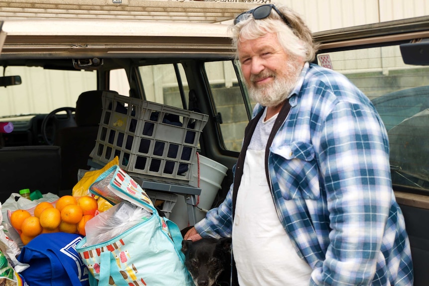 Max Kalz with his dog in the back of the car along with groceries.