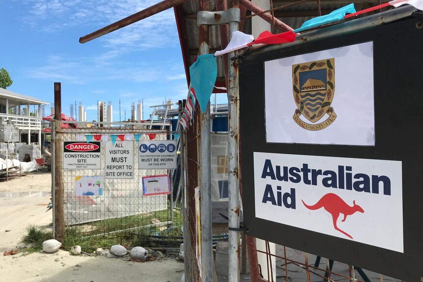 A construction site with a Tuvalu sign above an Australian aid sign.