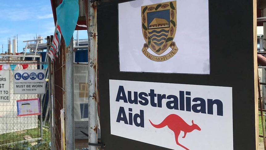 A construction site with a Tuvalu sign above an Australian aid sign.