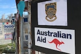 A construction site with a Tuvalu sign above an Australian aid sign.