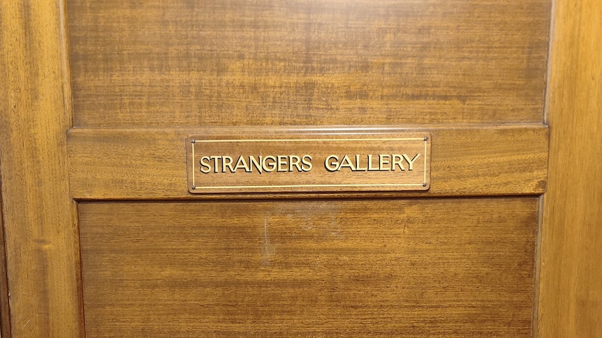 A sign saying STRANGERS GALLERY on a wooden door