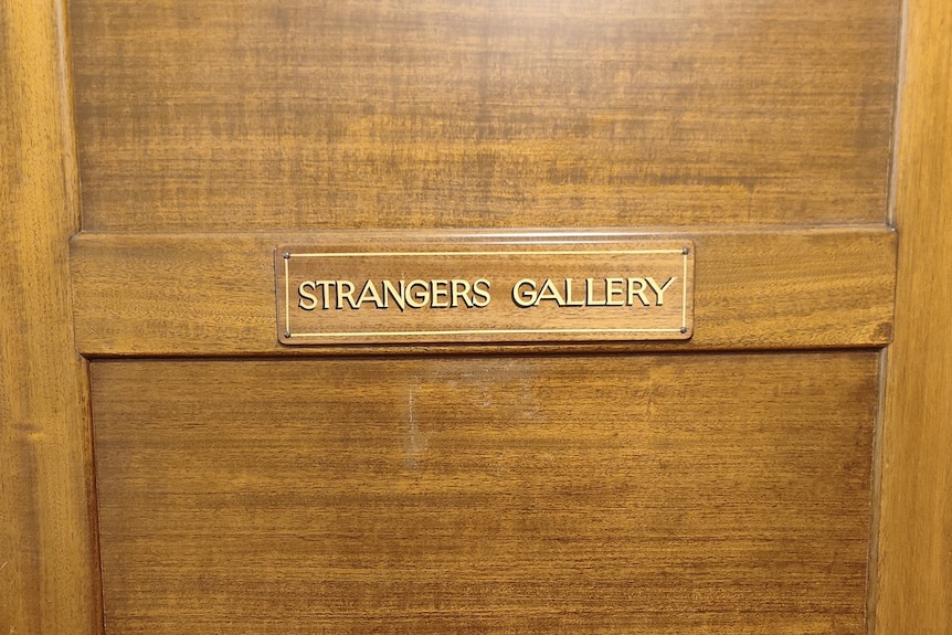 A sign saying STRANGERS GALLERY on a wooden door
