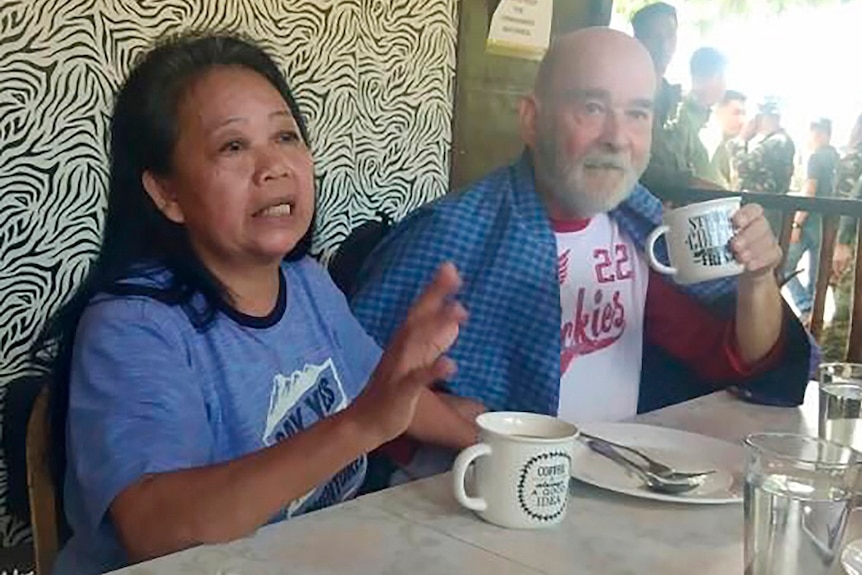 British national Allan Hyrons and his Filipino wife Wilma sitting at a table with coffee cups.