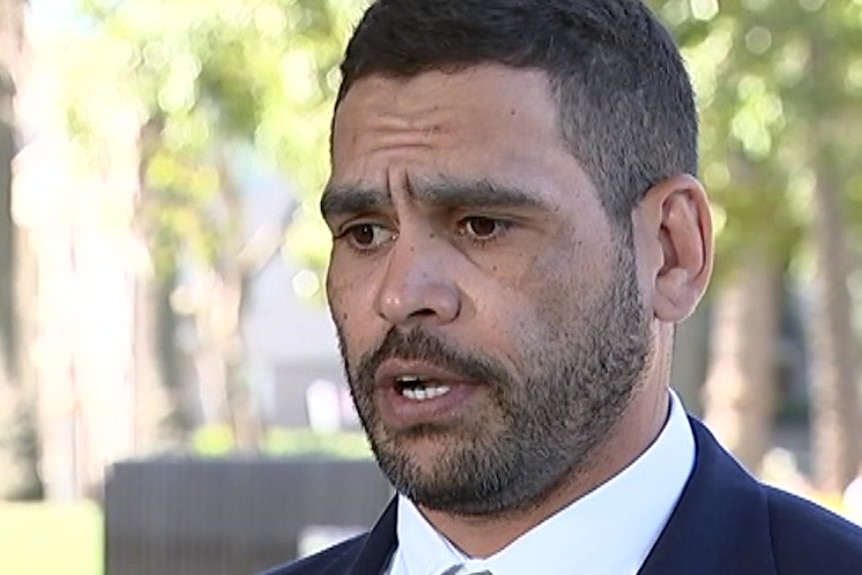 A man, looking remorseful, speaks to camera