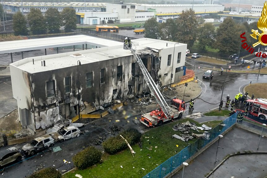 A drone shot shows the charred site of a small plane crash in Milan