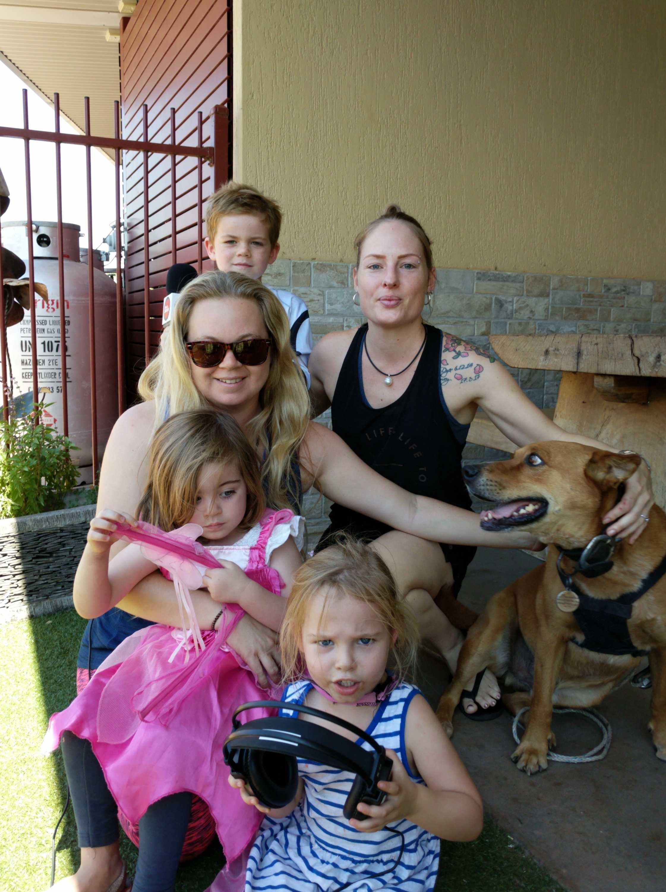 The two are pictured with three children and a dog