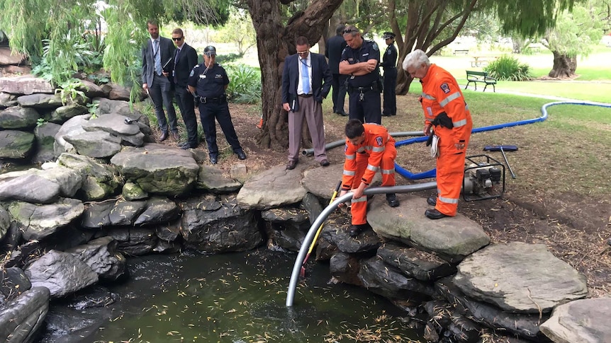 SES volunteers drain the Veale Gardens pond.