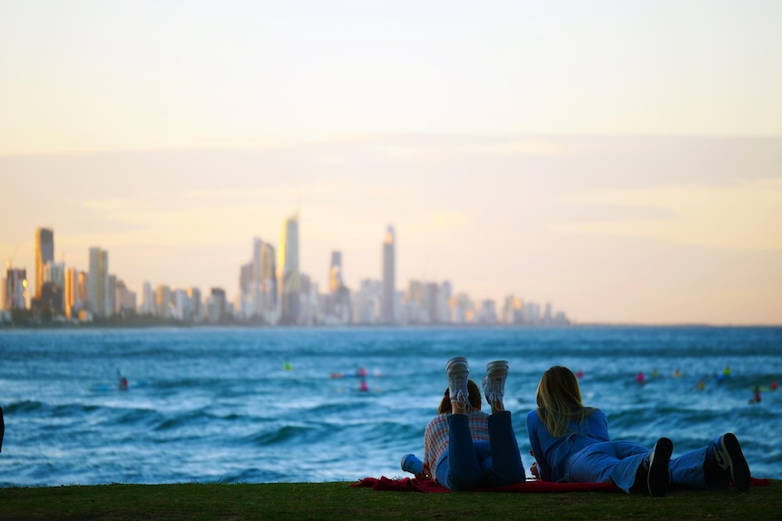 Two girls looking at Surfers Paradise skyline across the sea.