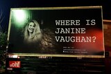 A billboard featuring a portrait of Janine Vaughan.
