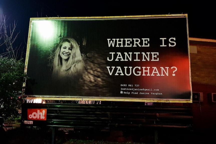 A billboard featuring a portrait of Janine Vaughan.