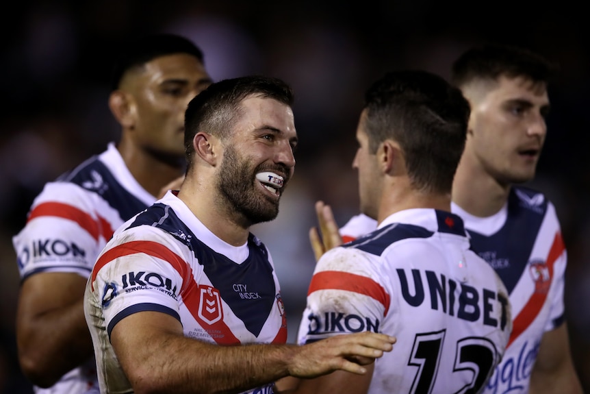 James Tedesco smiles among Sydney Roosters teammates.