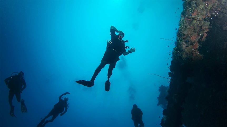 Man with mechanic leg swims underwater