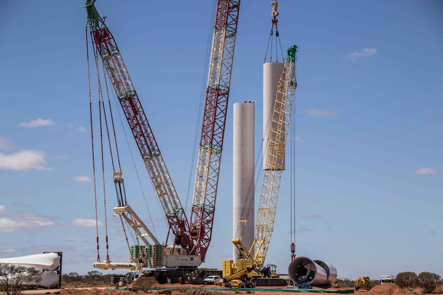 A crane lifting components for a wind turbine into place.