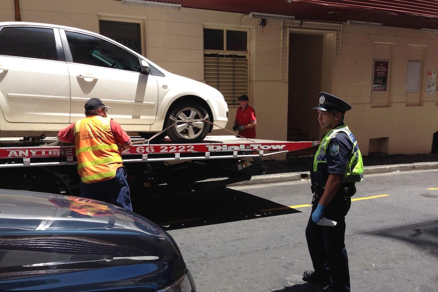 Car being towed away from Adelaide's Hotel Grand Chancellor after a woman's body was found in a room, January 1 2015.