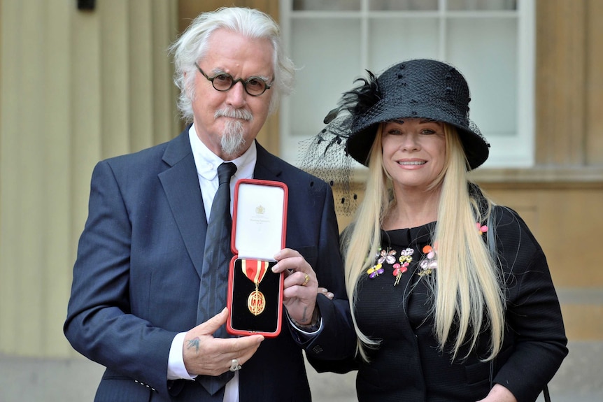 Billy Connolly and his wife Pamela Stephenson pose after he was knighted by Britain's Prince William.