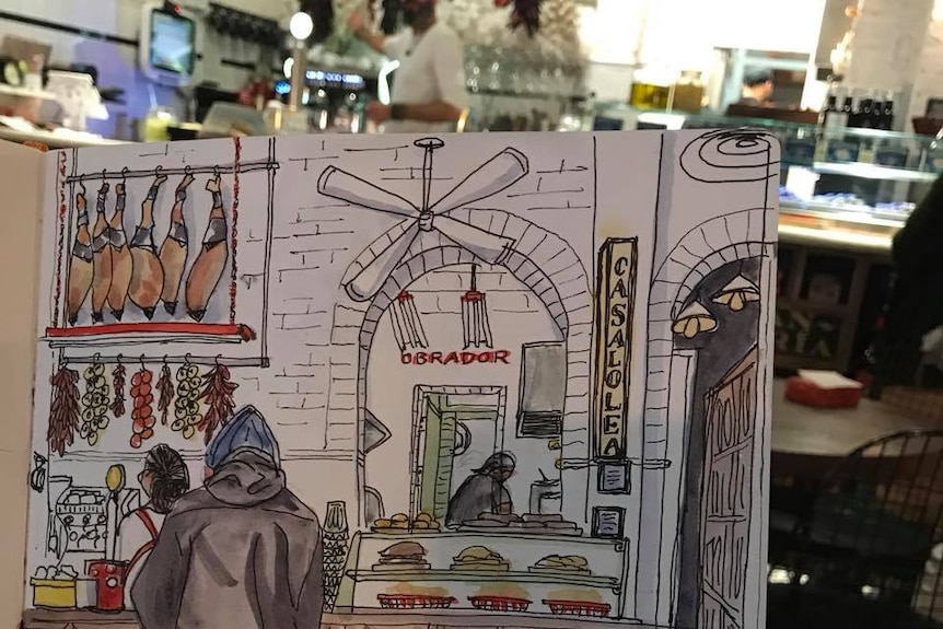 A sketch book with a drawing of a Spanish cafe.