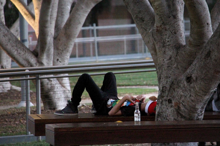 A new year's reveller rests under a tree in Brisbane shortly after sunrise on January 1, 2014.