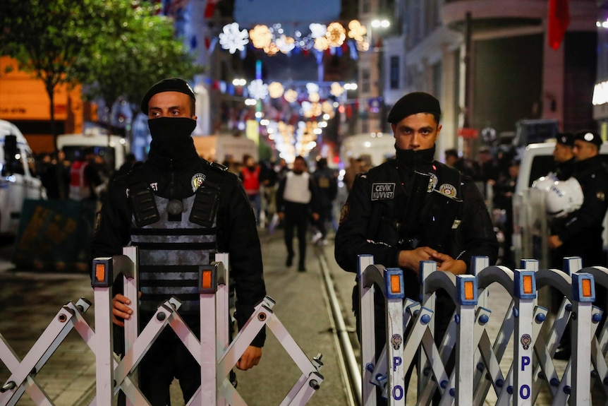 Police officers stand behind barricade on the street where an explosion occurred.