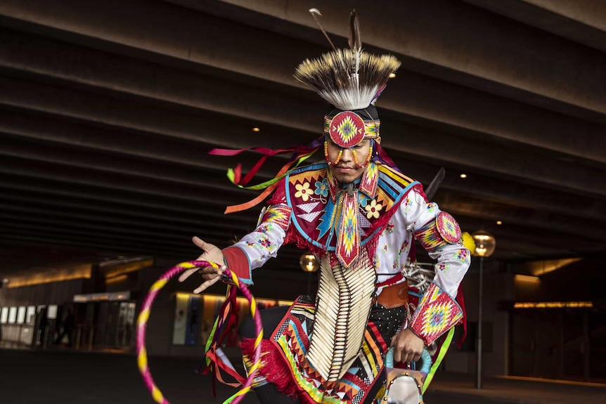 Colour photo of Ty Lodgepole of Indigenous Enterprise performing under Sydney Opera House podium near Stage Door.