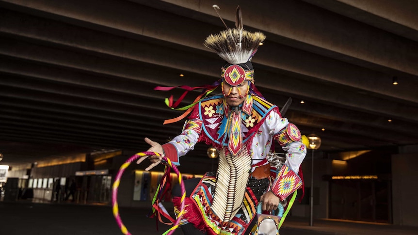 Colour photo of Ty Lodgepole of Indigenous Enterprise performing under Sydney Opera House podium near Stage Door.