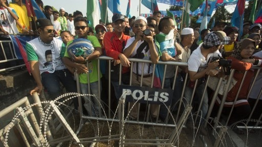 Supporters of Malaysia's opposition leader watch as Anwar Ibrahim (unseen) submits his election nomination.