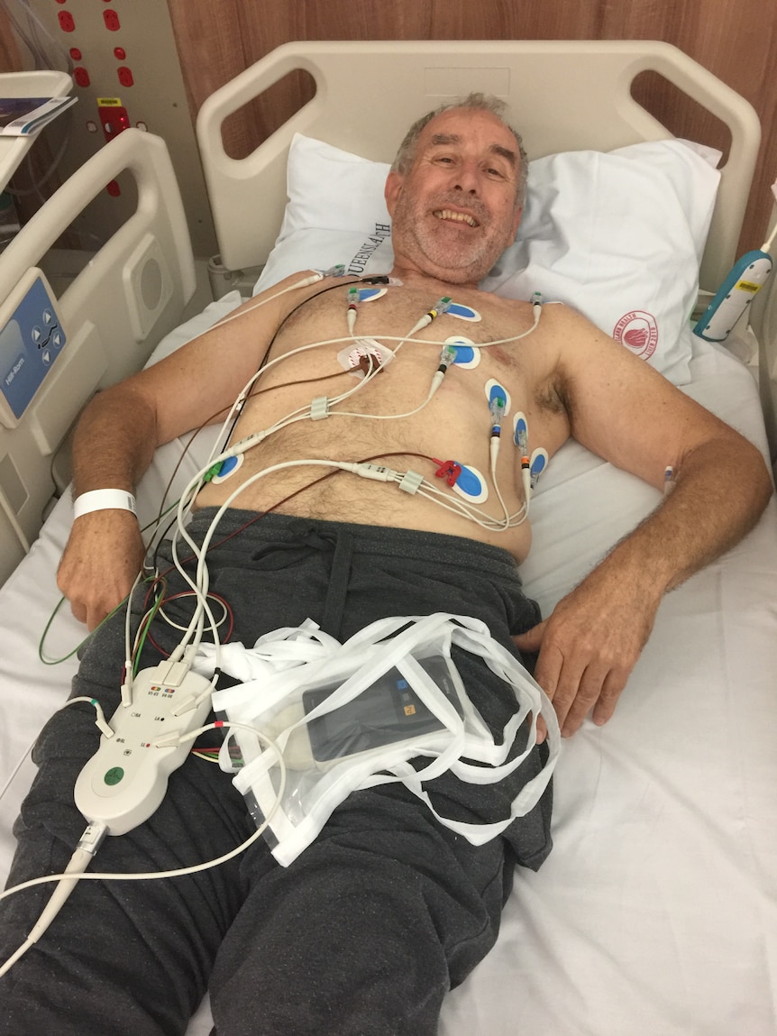 Steve Connelly lies in a hospital bed as his heart is monitored. 